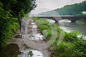 An old man cycling near the Cavour Channel along the Francigena trail