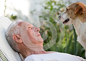 Old man with dog in garden