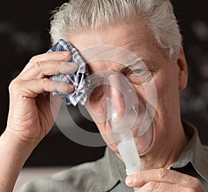 An old man doing inhalation