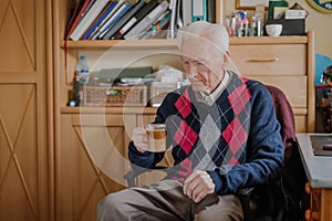 Old man drinking coffee at home