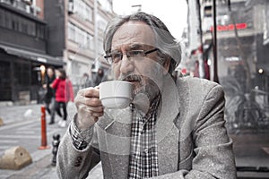 Old man drinking coffee in outdoors