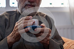 Old man drinking coffee with smile on his face