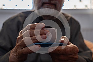 Old man drinking coffee with smile on his face