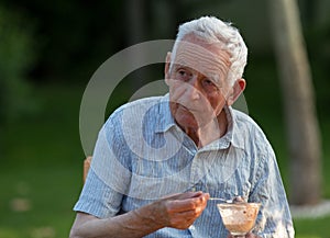 Old man eating ice cream in garden