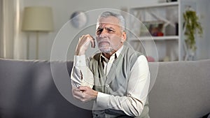 Old man feeling sharp pain in elbow, symptoms of arthritis, ligament injury