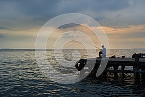 Old man fishing at the dock