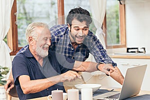 Old man fun smile happy to looking at laptop with son. using communication technology for family happiness elder home care to