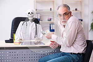 Old man giving money to dead doctor