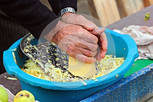 Old man grates a squash. Hands hold grater and vegetable photo