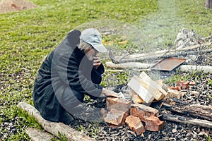 old man with a gray beard smokes in the village