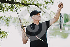 Old Man with Gray Hair Fishing on River in Summer.