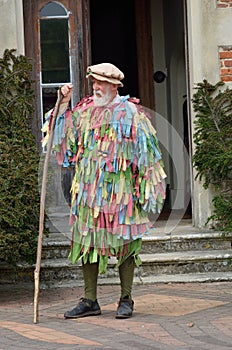 Old Man with grey beard in May Day re-enactment standing with stick