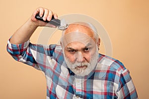 Old man hair treatment. Gray man hair clippings. Bald man hairclipper, Mature baldness and hair loss concept.