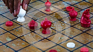 Old man hand moving Thai Chess Figure on Wood Checkerboard photo