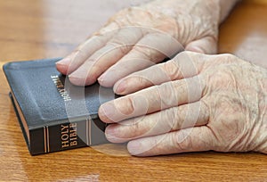 Old man hands on bible