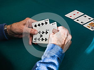 Old man hands playing cards in home