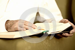 An old man hands reading the Koran. Selective focus