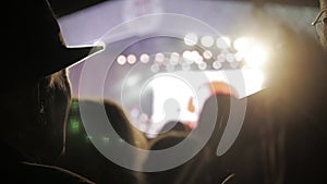 Old man in a hat at . crowd at concert - summer music festival. Concert crowd attending a concert, people silhouettes