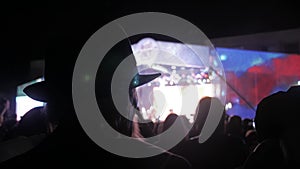 Old man in a hat at . crowd at concert - summer music festival. Concert crowd attending a concert, people silhouettes