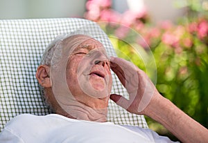 Old man having headache in garden