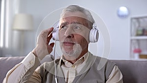 Old man in headphones listening to romantic song, remembering love feelings