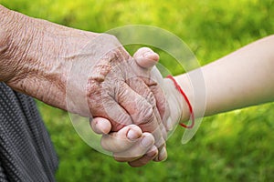 Old man holding child`s hands. selective focus