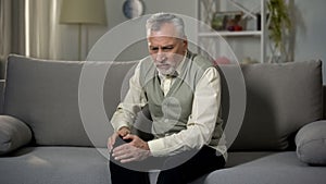 Old man holding knee, suffering joint pain, senior arthritis, osteoporosis