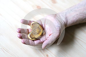 Old man holding a wooden heart in his hands, a gift for Valentine`s Day, focus on hands and a heart
