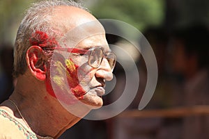 Old man in Holi color festival.