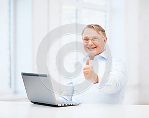 Old man with laptop computer showing thumbs up