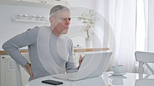 Old Man with Laptop having Back Pain at Home