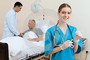 The old man lies on a cot in the medical ward, and next to him there is a doctor and a nurse.