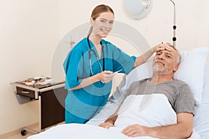 The old man lies on a cot in the medical ward, and next to it there is a nurse.