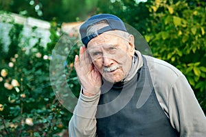 Old man in a listening position. The old man listens to the conversation