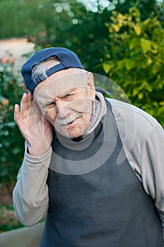 Old man in a listening position. The old man listens to the conversation