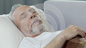Old man lying in bed and having nap, good health and sound sleep, afternoon rest