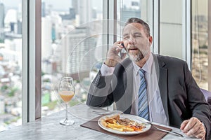 Old man manager eat spaghetti in italian restaurant