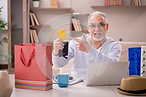 Old man with many bags in Christmas concept at home