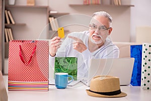 Old man with many bags in Christmas concept at home