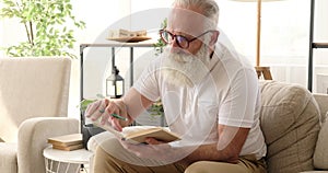 Old man marking with pencil while reading a book