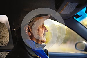 Old man with moustaches driving a car