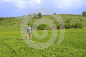 Old man mowing grass on the field