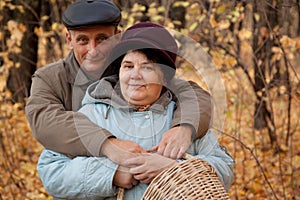 Old man and old woman with basket in autumnal fore