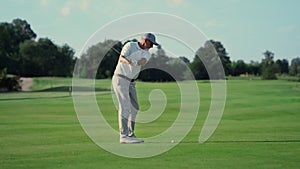 Old man play golf on grass fairway. Pro player swing club hitting ball outside.