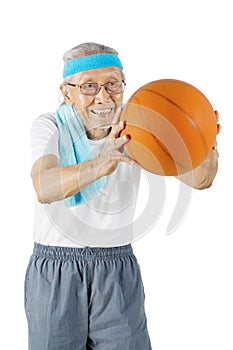 Old man play and pass a basketball in the studio