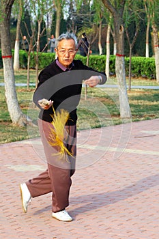 Old man play Taiji sword photo