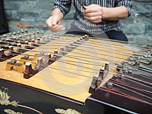 Old man playing with bamboo hammers on a yangqin