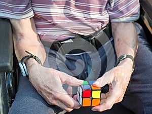 Old man playing a cube puzzle to help with brain injury and bleed.Hampshire,England,United Kingdom photo