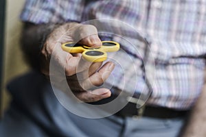 Old man playing with a fidget spinner