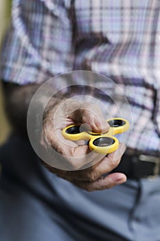 Old man playing with a fidget spinner photo